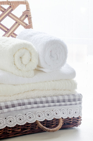 white towels in a basket on white backgroundの写真素材