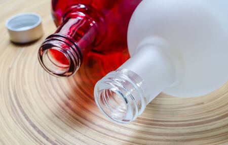 Close up of white and red glass bottle on bamboo plate,soft focus.の写真素材
