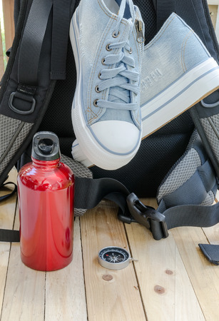 backpack  ,canvas shoes ,water canteen and compass on wooden background.の写真素材