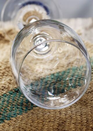 Close up view of empty wine glass on sackcloth background in nature light.の写真素材