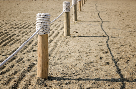 Wooden fence Tied with rope on the sandの写真素材