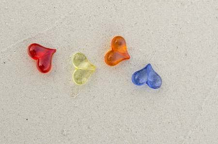 Colorful of heart shape plastics on the sandの写真素材