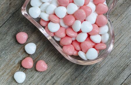 Colorful and sweet candies  in glass plate on wooden table.Top view.の写真素材