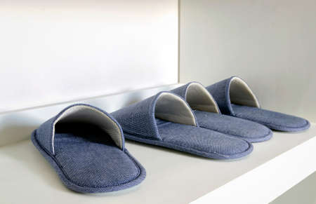 Blue house slippers on white shelfの写真素材