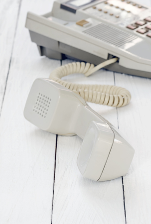 telephone with handset down on the side on white wooden background,soft focus.の写真素材