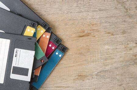 Used floppy diskettes on wooden background.の写真素材