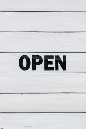 White wooden wall with black color printed word"open",for background.の写真素材