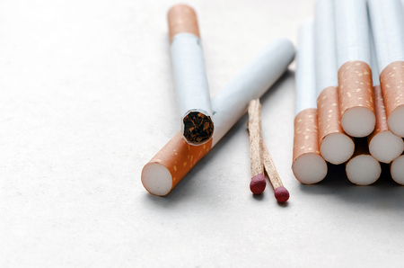 cigarettes and match on white paper background.Shallow DOF.の写真素材