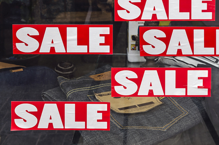 Red Sale Sign on old jeans store showcases.の写真素材