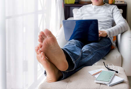 man using  laptop working  on a comfortable sofa at home.の写真素材
