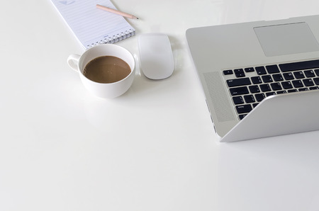 Laptop on white table with copy space.