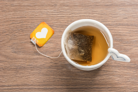 Cup of tea with tea bag on wooden backgroundの写真素材
