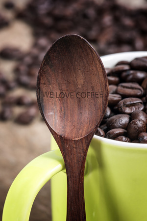 Wooden spoon and green cup of coffee beans,love coffee concept.の写真素材