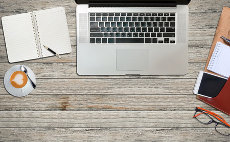 laptop and office supplies  on a wooden table background,top viewの写真素材