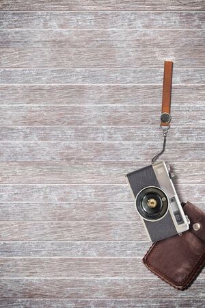 vintage camera and leather bag on wooden background.の写真素材