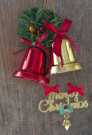 Red and Golden christmas bells on wooden background.の写真素材