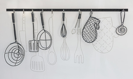 wire kitchen utensils hang on the white wall,for decorateの写真素材