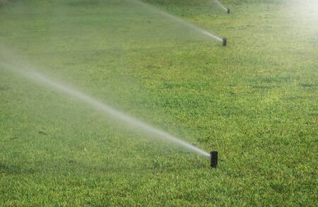 water sprinkler in grass Fieldの写真素材