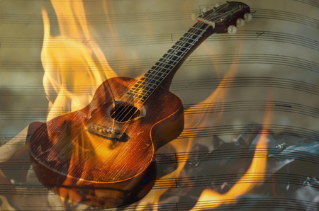 Acoustic guitar on fire flame screenの写真素材