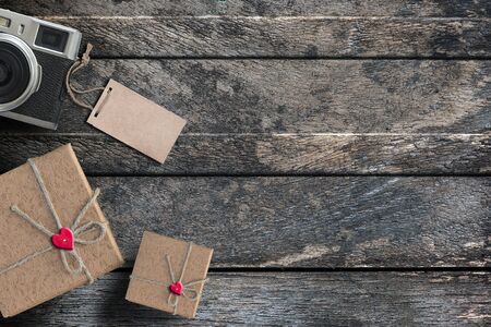 Gift box with red heart and vintage camera on wooden table background.For New Year Day and Valentine Day backgroundの写真素材