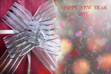red gift box with ribbon and bokeh for happy new year background.