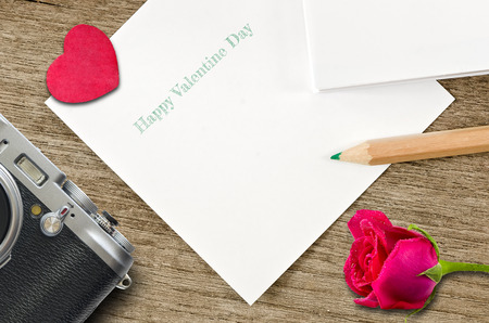 white note ,red heart,old camera,rose and pencil on wooden background,valentine day conceptの写真素材