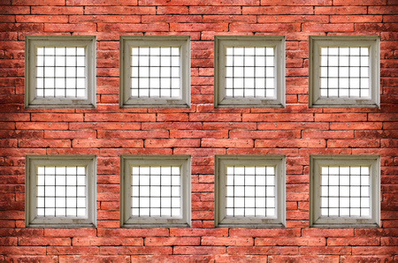 windows with bars of iron on red old  brick wall,with clipping pathの写真素材