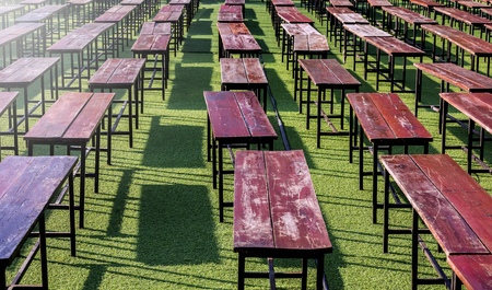 row of old wooden  bench on green grassの写真素材