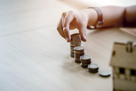 hand of young girl holding  coins on a table, Select focus at coins, Saving conceptの写真素材