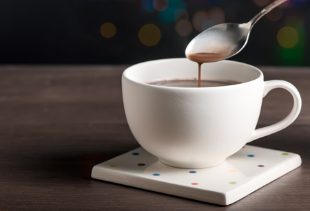 A white cup of coffee with dark and bokeh backgroundの写真素材