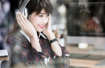 Young asian  woman listening to music with  headphonesの写真素材