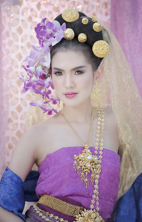 Young beautiful woman in Thai traditional dress with  flower  on her hairの写真素材