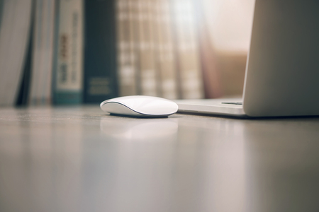 Close up image of mouse and laptop on the table with morning sunlightの写真素材