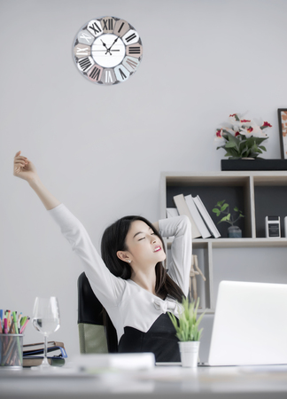 Beautiful business woman sitting on the chair stretch oneself at modern officeの写真素材