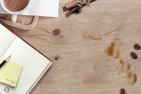 Top view of cup of coffee, blank notebook and coffee bean on wooden top table, copy space for text.の写真素材