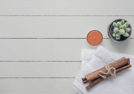 Top view spa concept with white towels, candle and houseplant on white wooden background, copy space.の写真素材