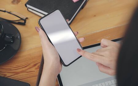 Closeup female hand holding smartphone with blank screen for graphics display montage.の写真素材