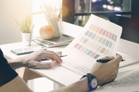 Close-up professional designer working color chart and computer at studio.の写真素材