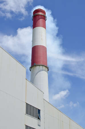 A photo of red and white factory stack that used for release some smoke の写真素材