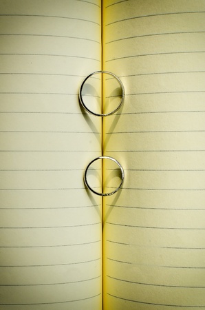 Groom's and Bride's ring casting a heart shadow onto a bookの写真素材