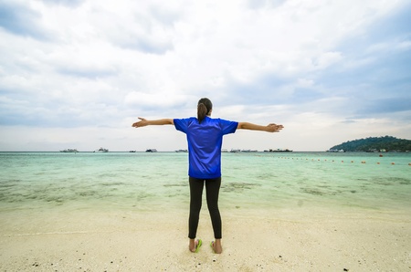 Happy girl on the beach against blue seaの写真素材