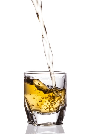pouring whiskey isolated on white backgroundの写真素材