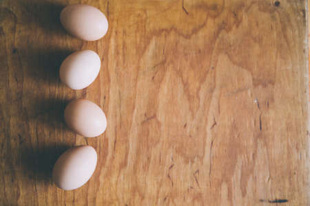 four eggs on wood board with space for textの写真素材