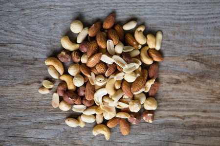 assorted various nuts closeup on wood boardの写真素材