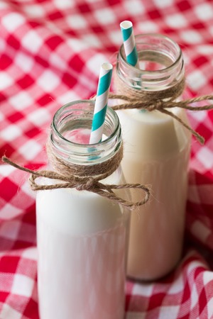 two milk bottle with blue retro straw on red clothの写真素材