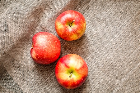 group of three apples on rustic fabric backgroundの写真素材