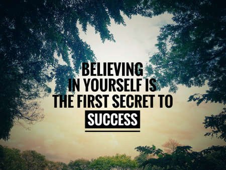 Motivational and inspirational quote - Believing in yourself is the first secret to success. Blurred background of trees and sunset.の写真素材