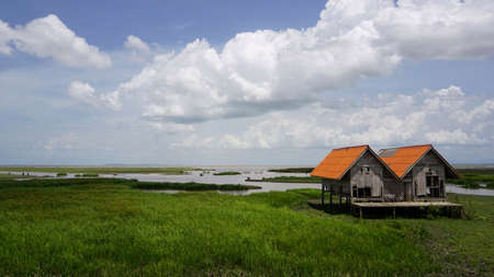 A landscape view of an old house by the lake located in Thanon Chaloem Phra Kiat 80 Phansa, Phatthalung, Thailand.の写真素材