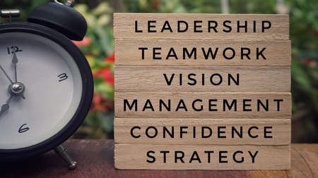 Business and financial Concept - Stacked wooden blocks with words âLeadership, Teamwork, Vision, Confidence, Strategy and Managementâ written on them.の写真素材