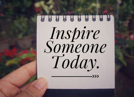 Motivational and inspirational quote - âInspire someone todayâ written on a notebook with blurred vintage styled background.の写真素材